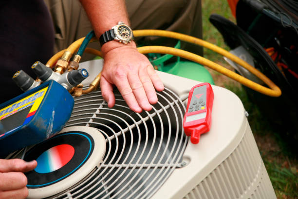 Technician servicing air conditioning unit